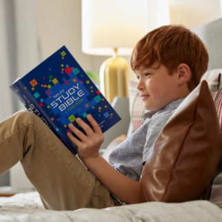 A boy holding the NKJV Study Bible for Kids