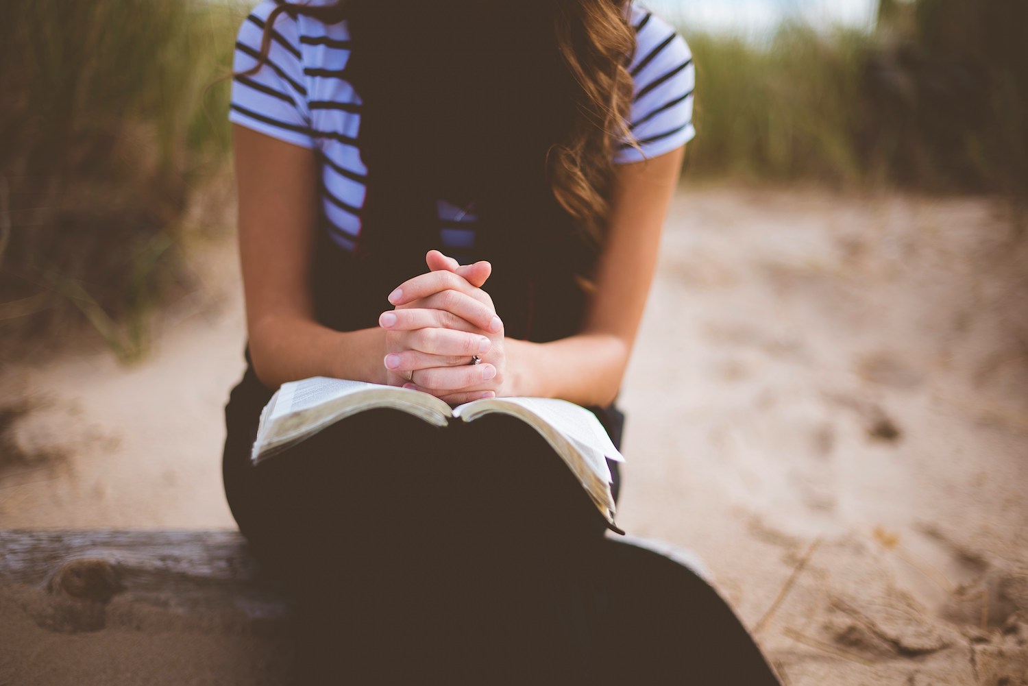 A woman praying over an open book